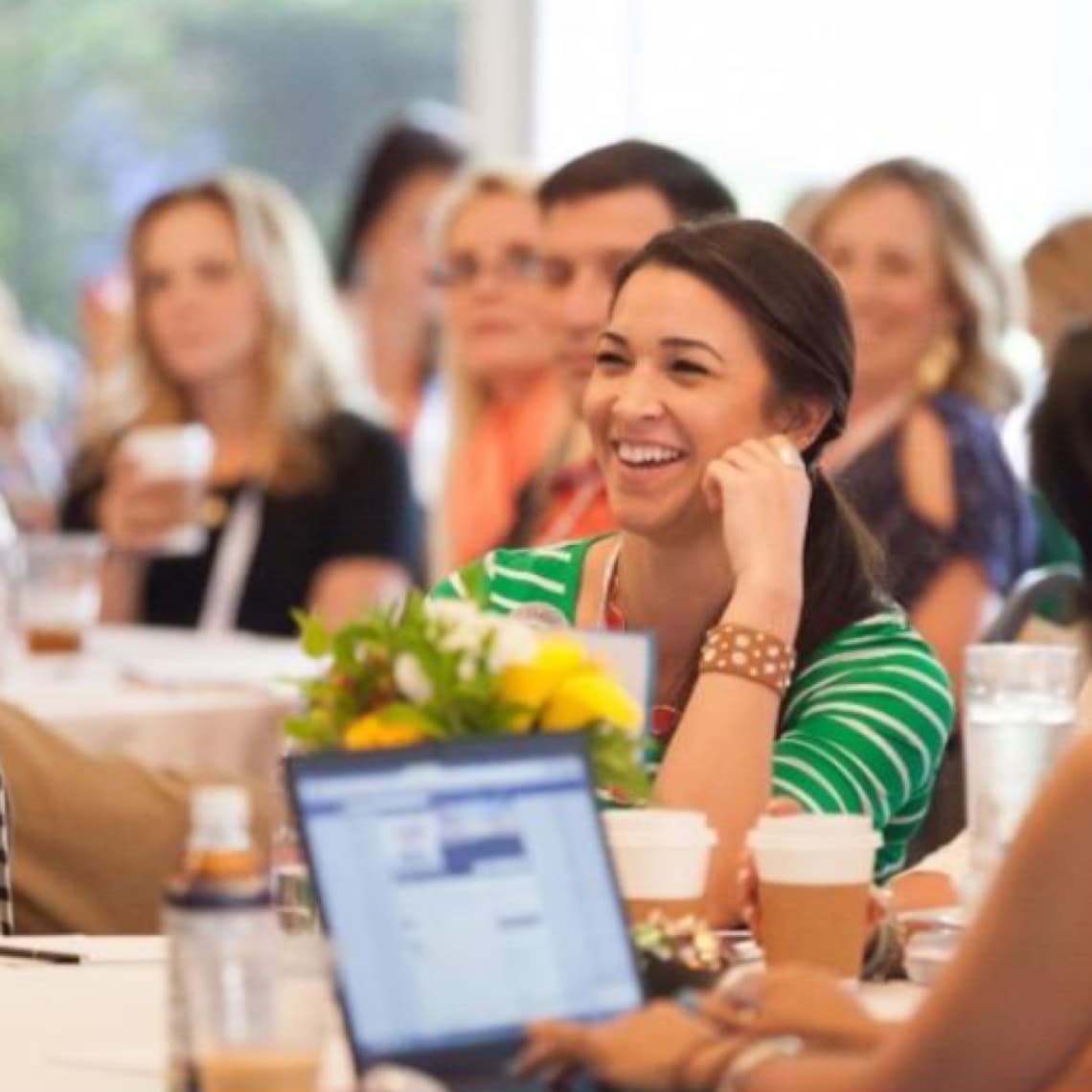 Woman sitting at a table at a live R+F event. Woman sitting at a table at a live R+F event.