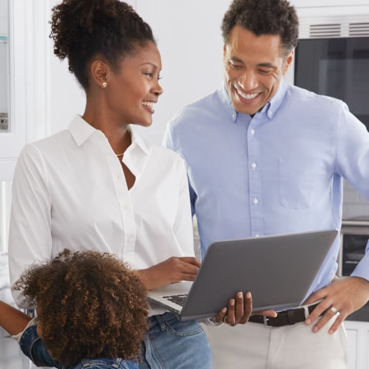 Two people talking and looking at a laptop. Two people talking and looking at a laptop.