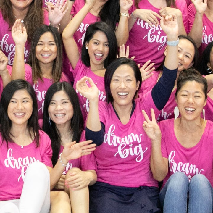 Group of women smiling wearing pink shirts that say dream big. Group of women smiling wearing pink shirts that say dream big.